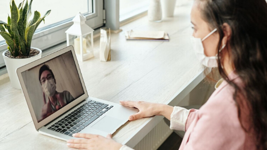 Woman is having video conference in front of a laptop PC