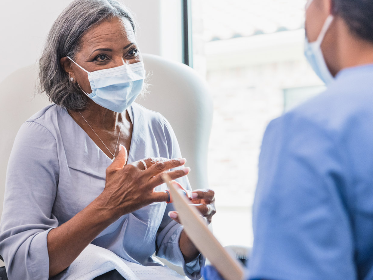 Patient wearing a mask and talking to their career