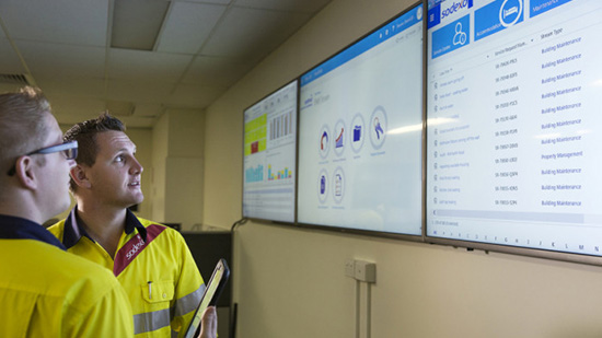 Two Sodexo employees looking at screens with numbers