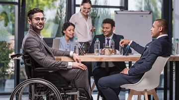 people discussing project  disabled person in work office
