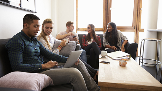 Students sitting on a sofa in university accomodation