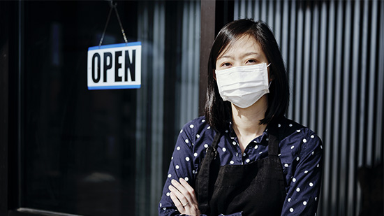 Sodexo front of house employee with open sign in background