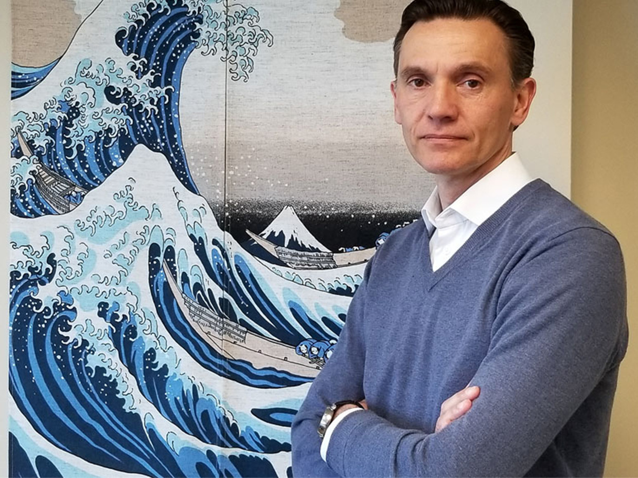 Mark Plumart in front of the painting The Great Wave Off Kanagawa