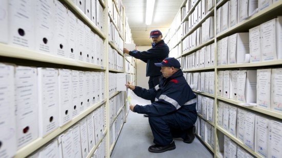 Two Sodexo employees sorting archived boxes of documents